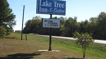Letrero del Lake Tree Inn & Suites con un mensaje de bienvenida para pescadores y acceso a internet.