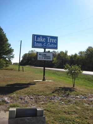 A sign for Lake Tree Inn & Suites with a welcome message for fishermen and internet access. - Laketree Inn And Suites Marion (Marion)