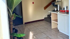 A small kitchen area with a coffee machine, a trash bin, and a potted plant. - Laketree Inn And Suites Marion (Marion)