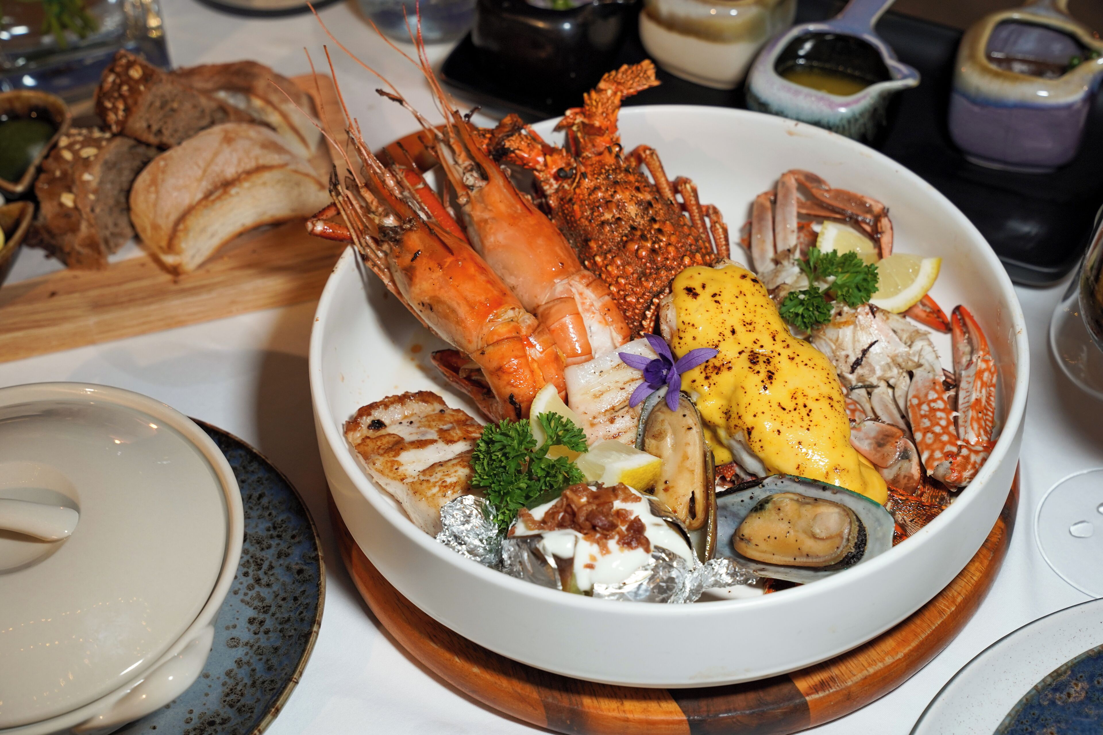 A seafood platter with various shellfish and a lemon wedge.