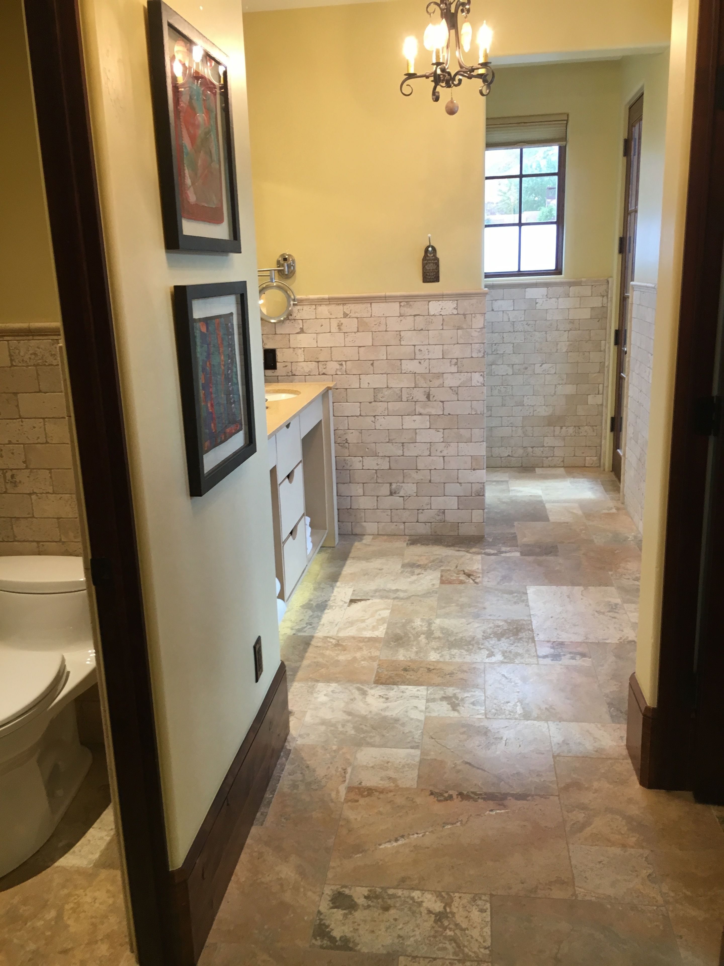 A bathroom with a white sink, a mirror, and a chandelier.