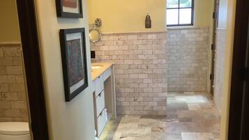 A bathroom with a white sink, a mirror, and a chandelier.
