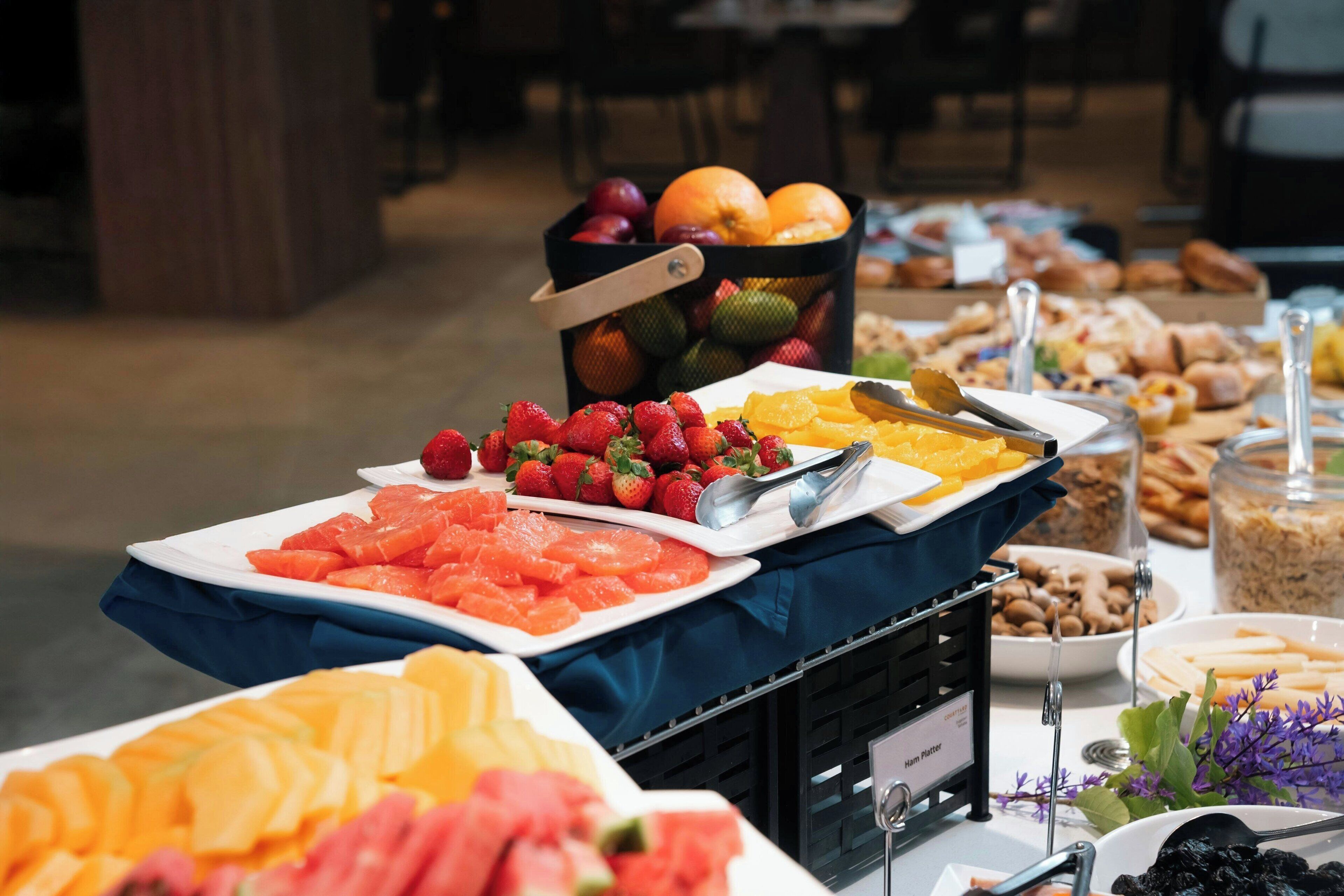 Un buffet proposant une variété de fruits et de pâtisseries.
