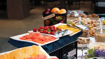 Un bufet amb diverses fruites i pastissos.