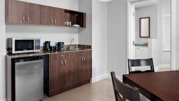 A compact kitchen with a microwave, coffee maker, and dishwasher.