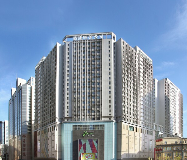 A modern high-rise building with multiple floors, featuring a prominent sign at the top. - Somerset Heping Shenyang (Shenyang)