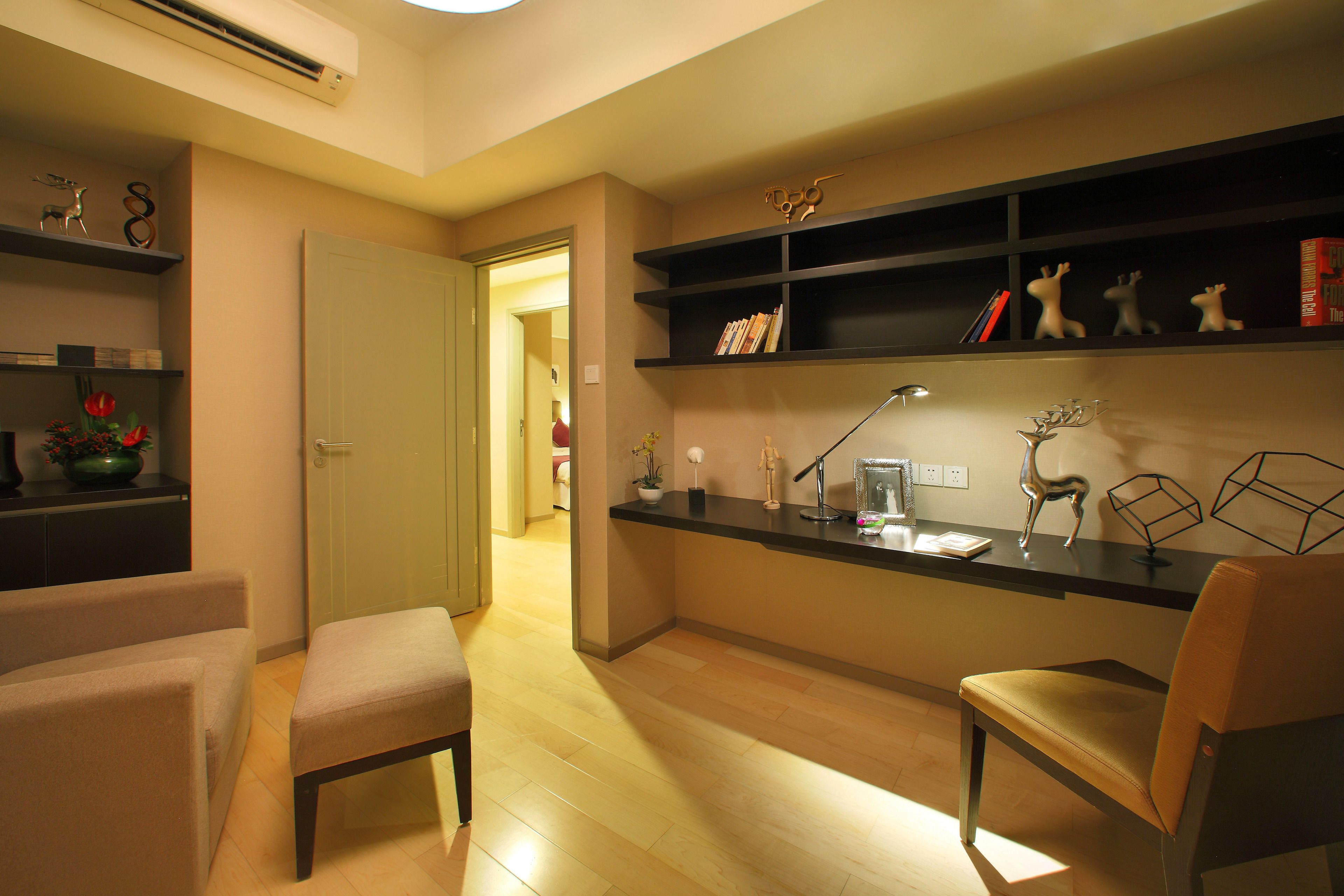 Una sala de estar moderna con suelo de madera, un sofá, una silla y un escritorio con estanterías.