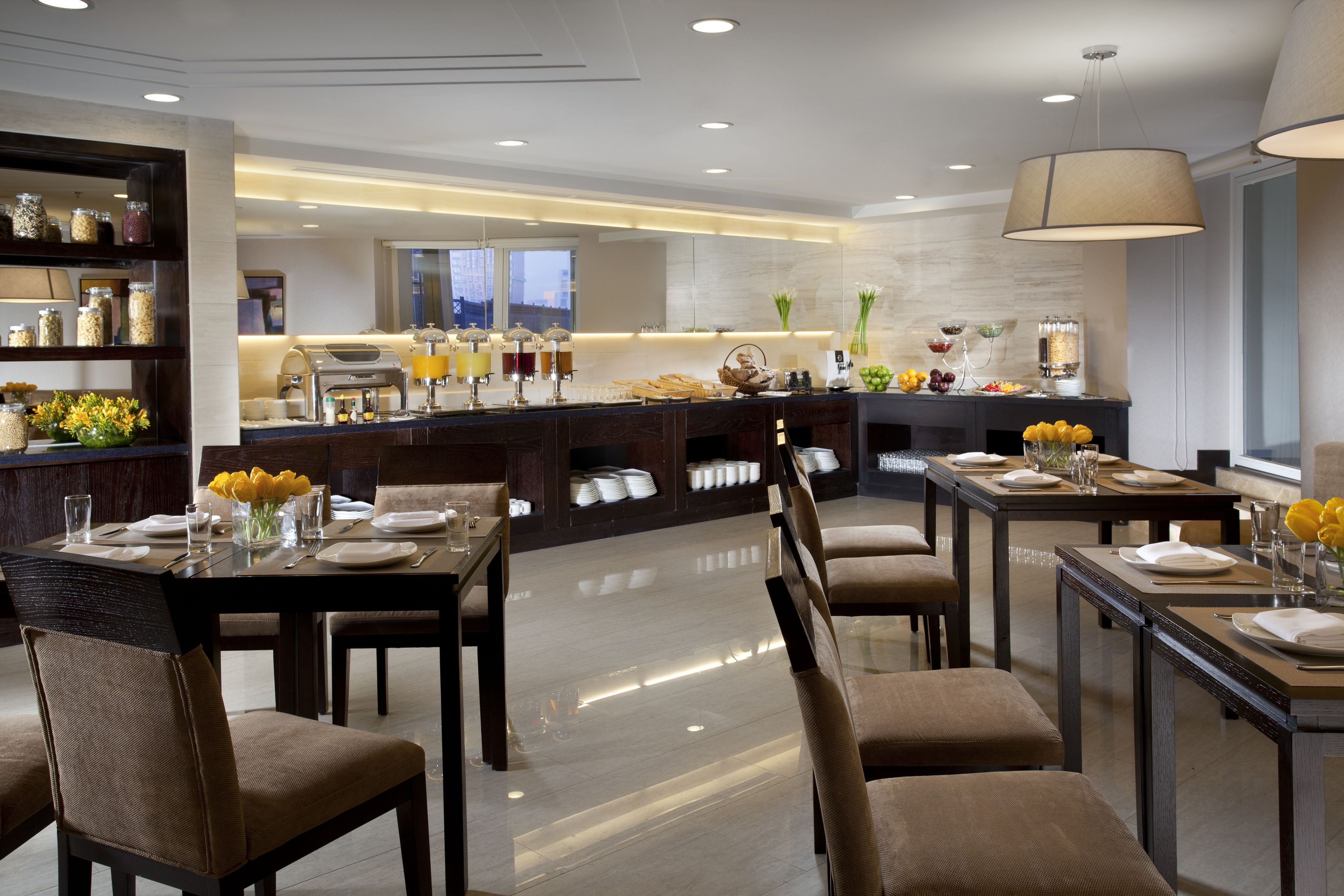 Een moderne eetruimte met een buffetopstelling, inclusief een koffiehoek en diverse gerechten.