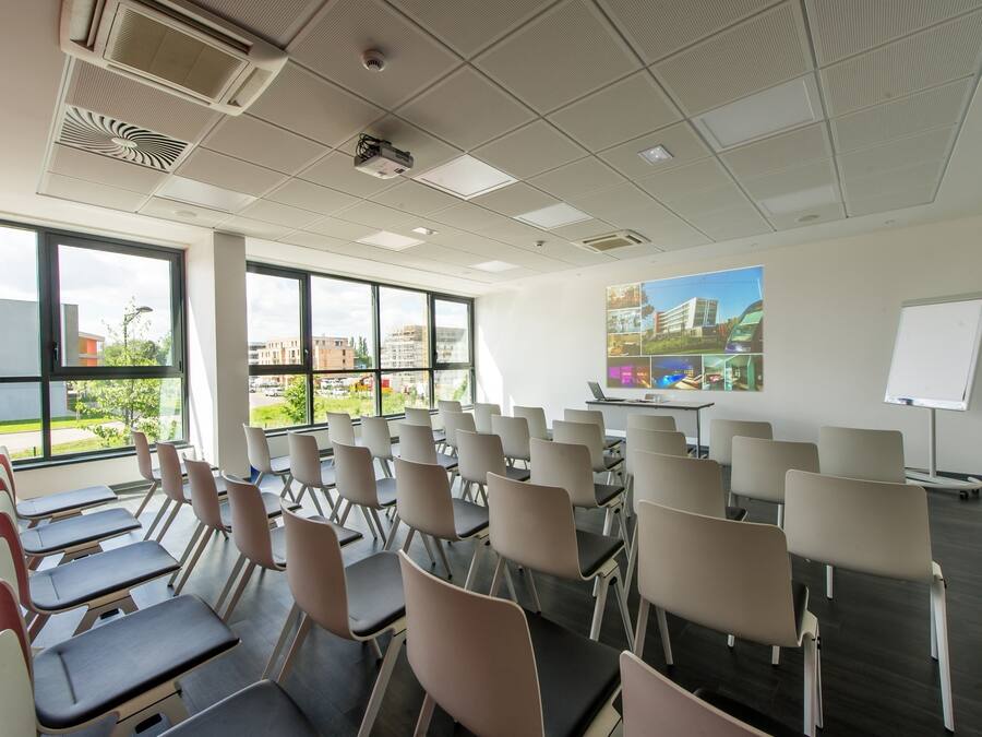 A conference room with rows of chairs, a projector, and a whiteboard.