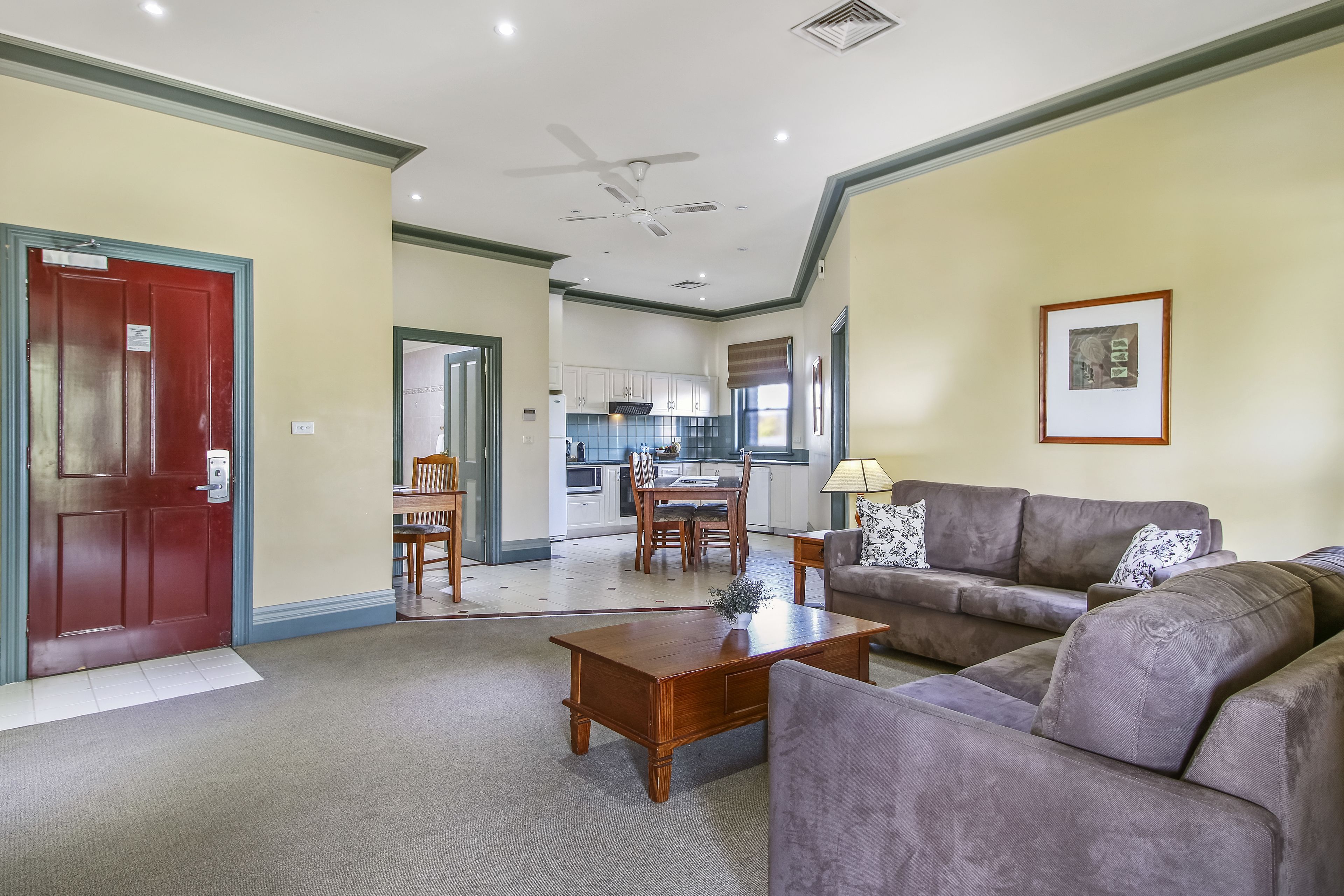 A living room with a sofa, coffee table, and a dining area with chairs and a table.