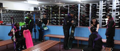 Un magasin de chaussures avec de nombreuses étagères remplies de chaussures et des bancs à la disposition des clients.