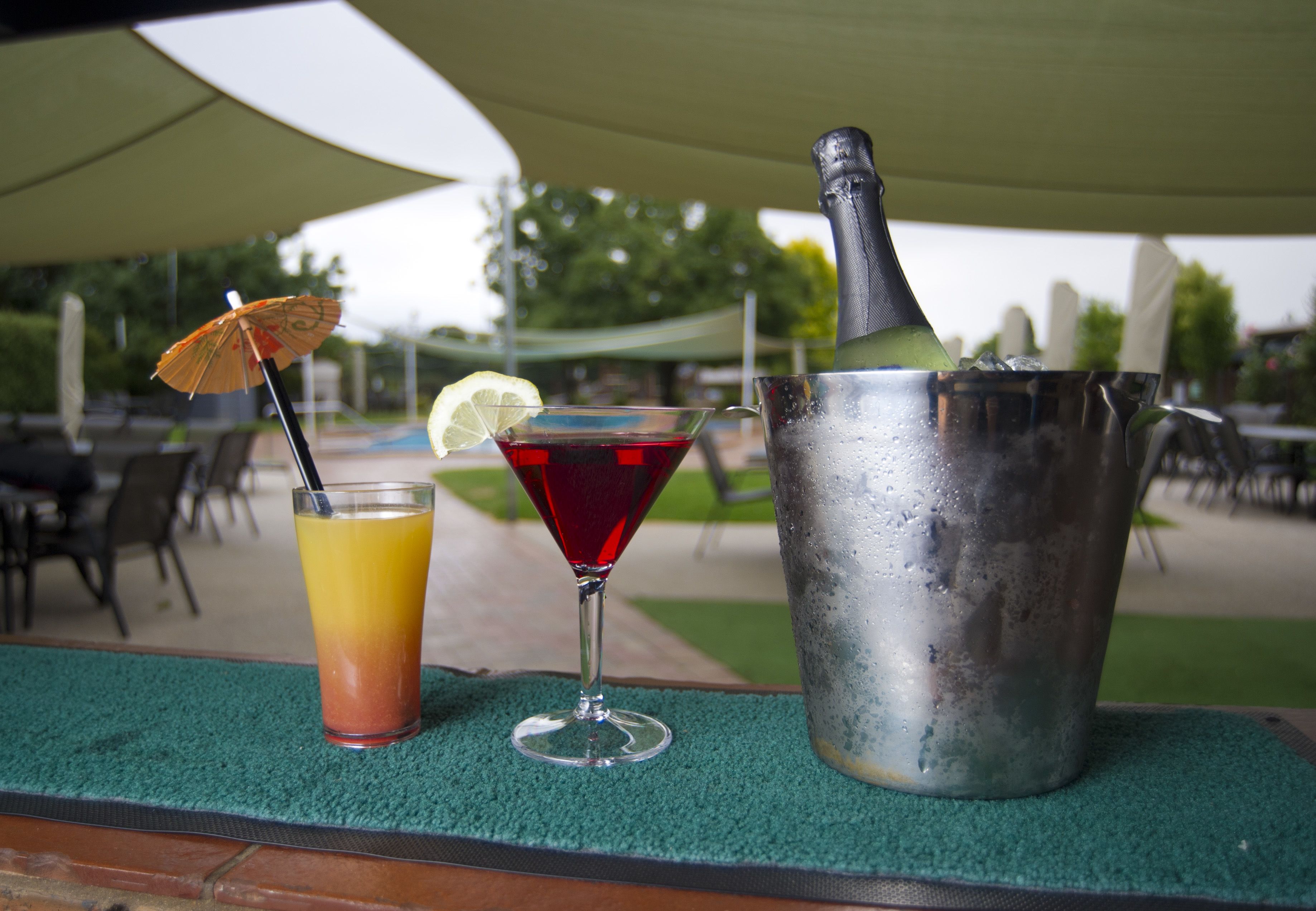 A table with a cocktail, a bottle, and a glass with a straw.
