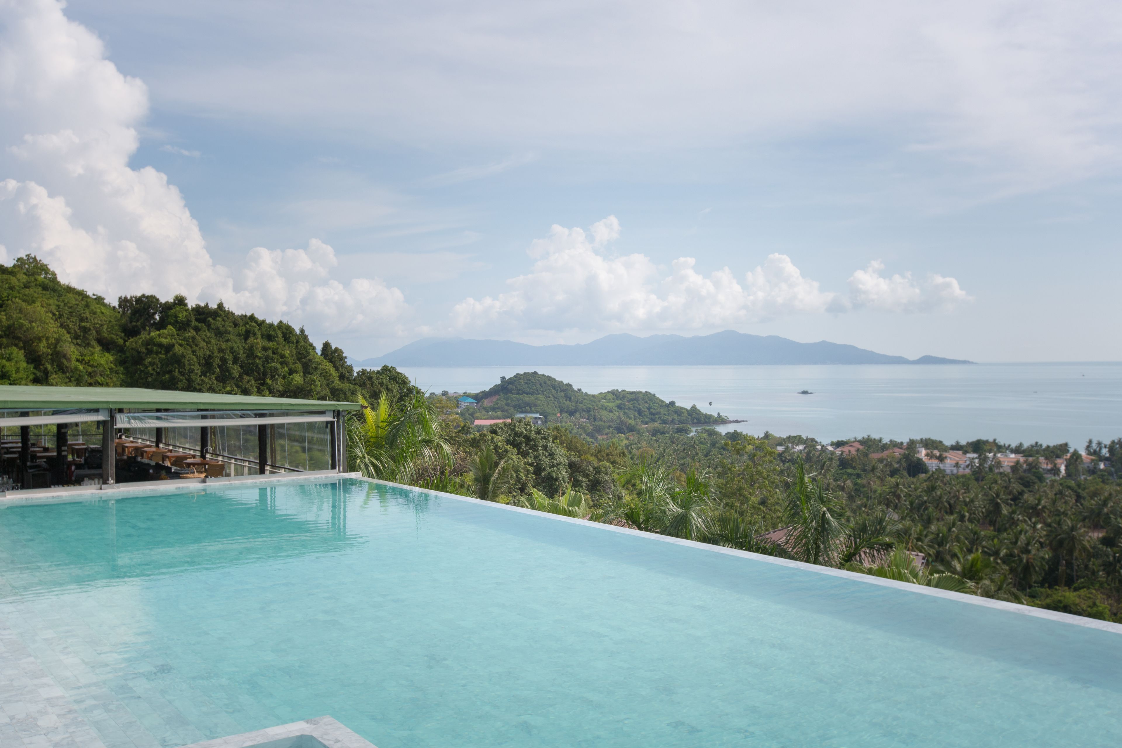Una piscina infinita con vistas al mar y las montañas.