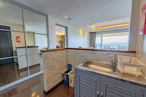 A modern kitchen with a marble backsplash, a built-in sink, and a window offering a view.