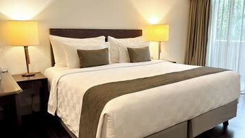 A neatly made bed with white and brown bedding, two bedside lamps, and a wooden headboard.
