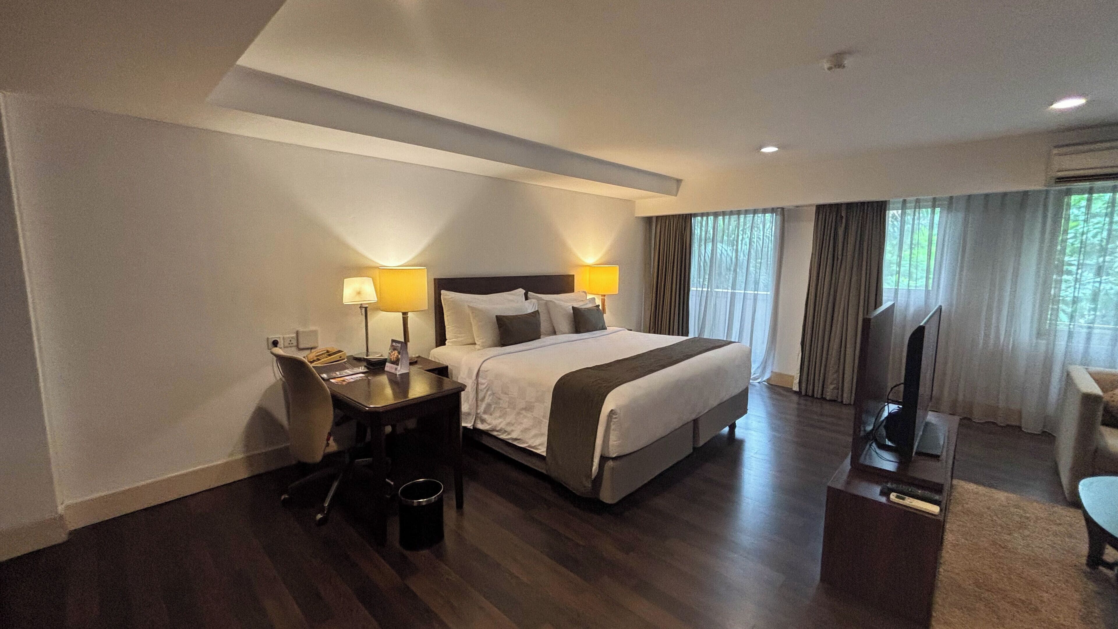 Une chambre d’hôtel équipée d’un lit, d’un bureau, d’une chaise et d’un téléviseur.