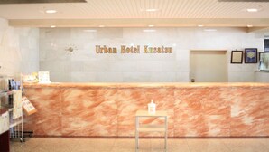 A reception desk with a marble counter and a clock above it.