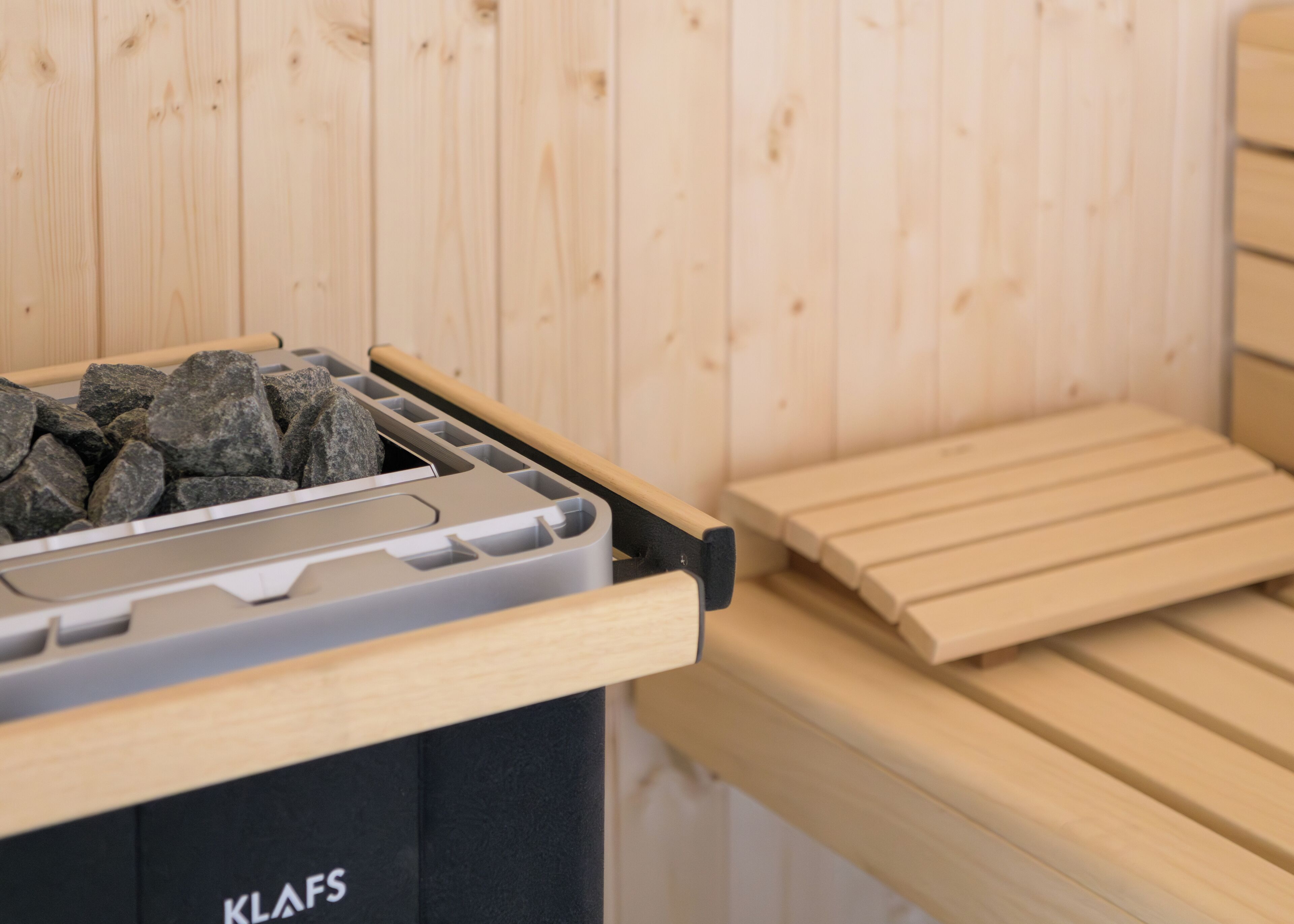 Un banc en bois et une poubelle entourée de pierres.