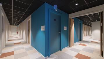 Un pasillo con puertas azules, piso a cuadros e iluminación empotrada en el techo.