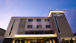 A modern hotel building with a sign reading "Hotel Santika Kuta." - Hotel Santika Kuta Bali (Kuta)