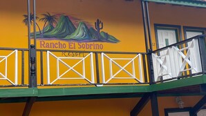 A building with a mural of mountains and a cactus, labeled "Rancho El Sobrino Resort." - Rancho El Sobrino (Sabana Westpunt)