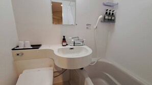 Une salle de bain avec un lavabo blanc, des toilettes, un miroir et une douche.