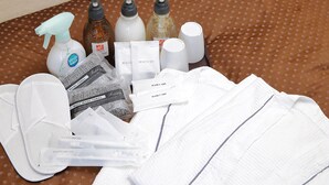 Une salle de bain équipée de produits de toilette, notamment des flacons de shampoing, d’après-shampoing et de gel douche, ainsi que des serviettes et une brosse à dents.