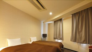 Une chambre d’hôtel avec un grand lit, un téléviseur à écran plat et un bureau avec une lampe.
