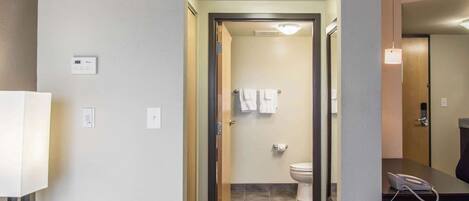 Ein Hotelbad mit Toilette, Waschbecken, Spiegel, Telefon und Handtuchhalter.