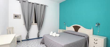 A bedroom with a bed, bedside tables, a chair, and a desk.