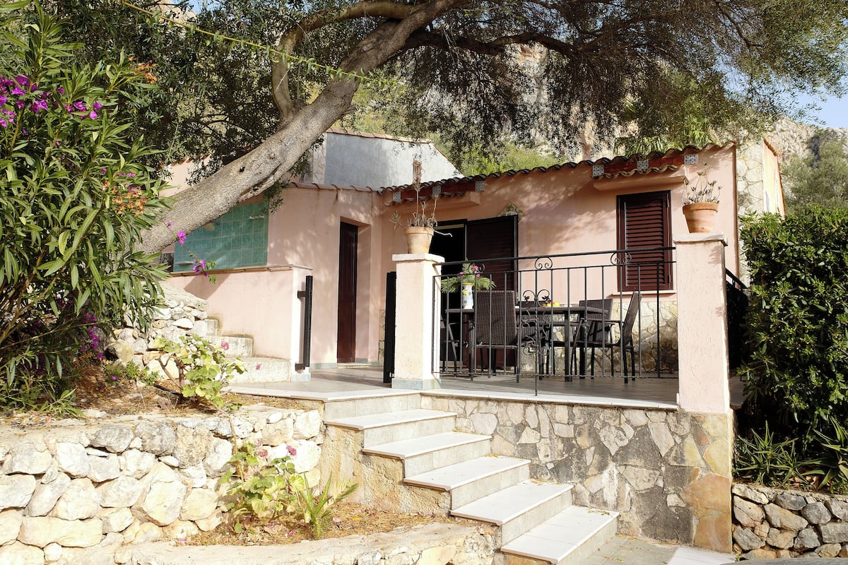 A stone staircase leading to a balcony with outdoor furniture.