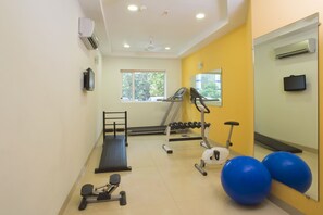 A gym with exercise equipment, a treadmill, dumbbells, and exercise balls. - Ginger East Delhi (New Delhi)