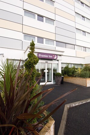 A hotel entrance with a sign reading 'Premier Inn' and a revolving door. - Premier Inn Manchester M56/J6 Runger Lane South (Altrincham)