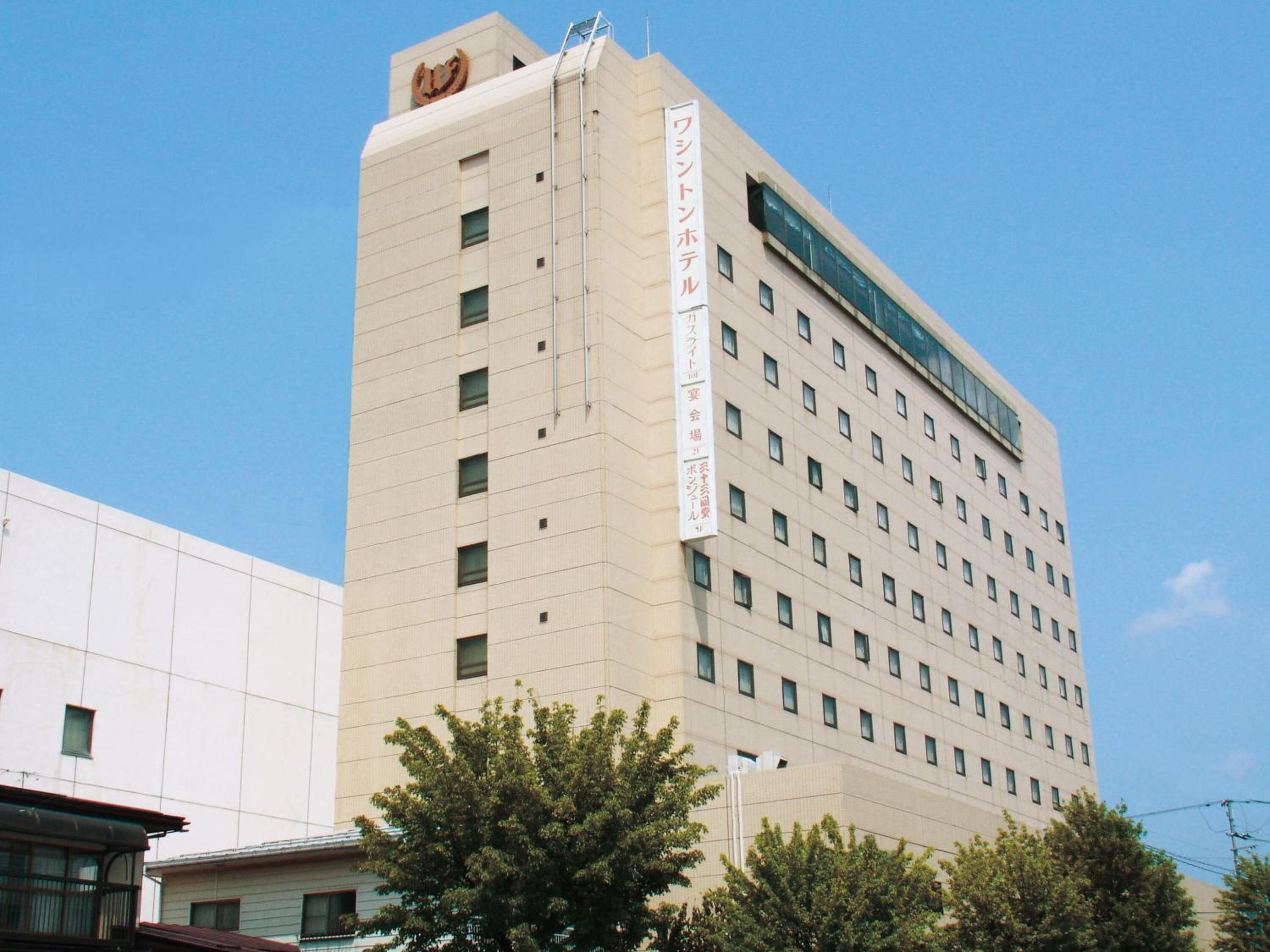 A tall, beige building with a sign indicating it is a hotel.