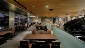 A modern restaurant with a grand piano, wooden ceiling, and city views. - Aizuwakamatsu Washington Hotel (Aizuwakamatsu)