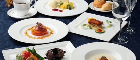 Une table dressée avec différents plats, notamment un gâteau au fromage, des fruits et un dessert aux baies.