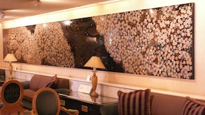 A hotel lobby with a large floral wall art, seating area with couches and chairs, and two table lamps. - Aizuwakamatsu Washington Hotel (Aizuwakamatsu)