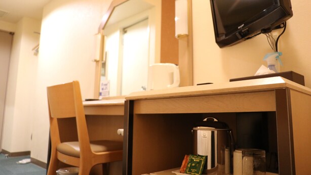 A hotel room with a wooden desk, a chair, a television mounted on the wall, and a coffee machine. - Aizuwakamatsu Washington Hotel (Aizuwakamatsu)