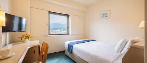 A hotel room with a bed, a desk, a chair, a TV, a window with a view, and a small picture on the wall.