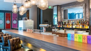 Un espace bar avec un comptoir, des tabourets et un miroir au-dessus du bar.