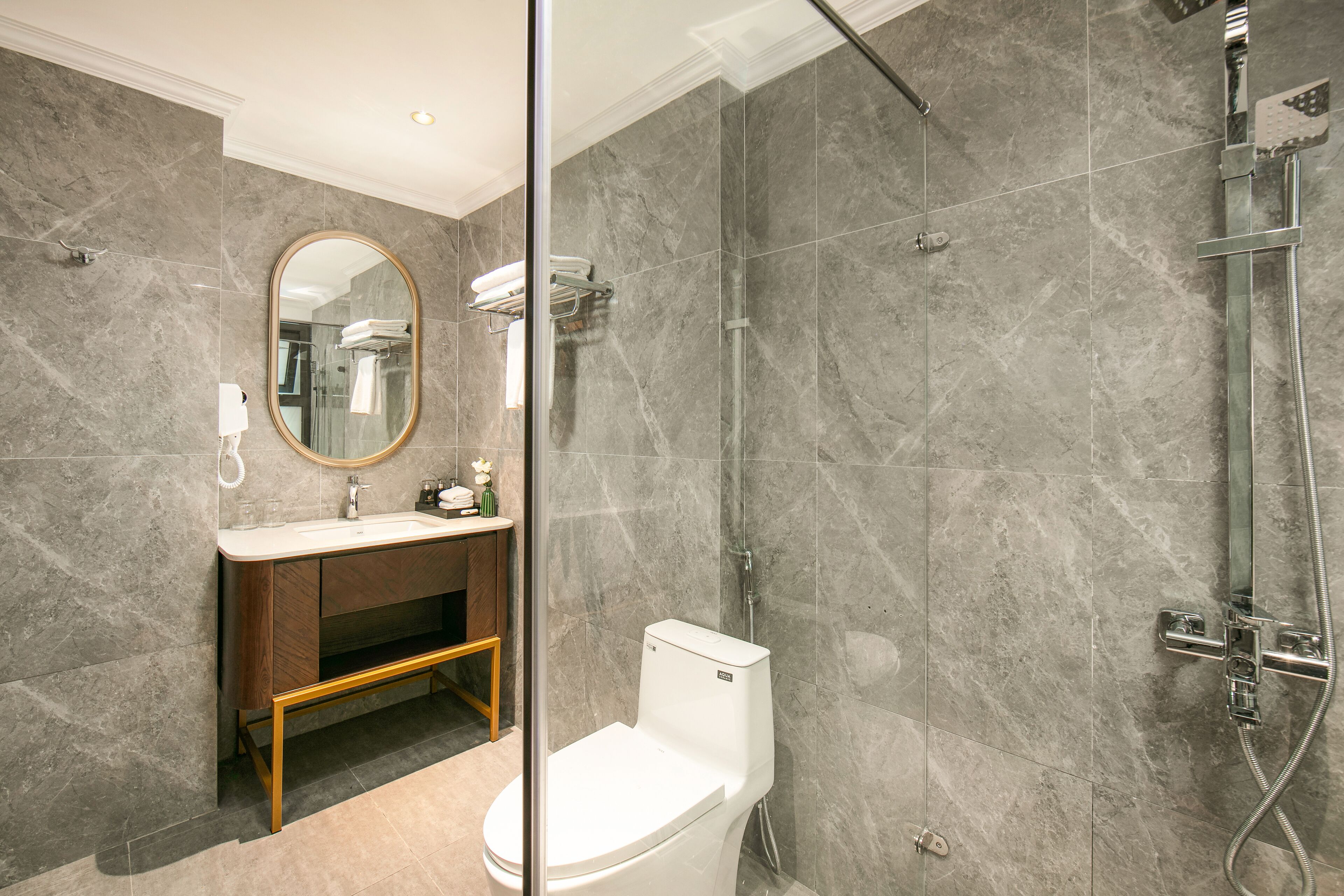 A modern bathroom with a toilet, sink, and shower.