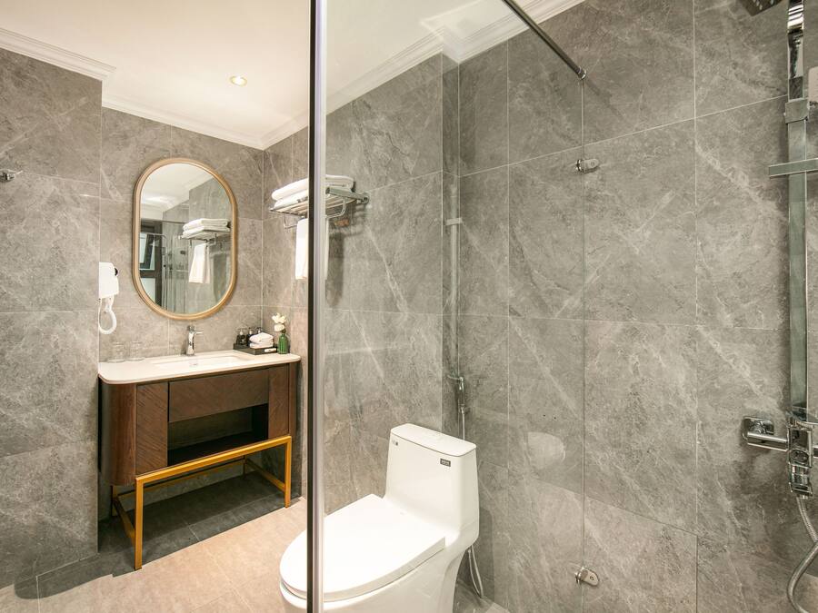 A modern bathroom with a toilet, sink, and shower.