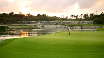 Golfers can enjoy a tranquil round on this serene course surrounded by water and lush greenery.