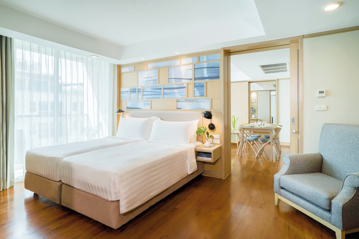 Une chambre d’hôtel avec un grand lit, un bureau et une chaise.