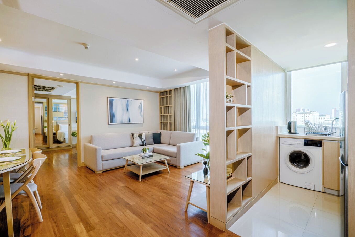 A modern living room with a sofa, coffee table, and a built-in bookshelf.