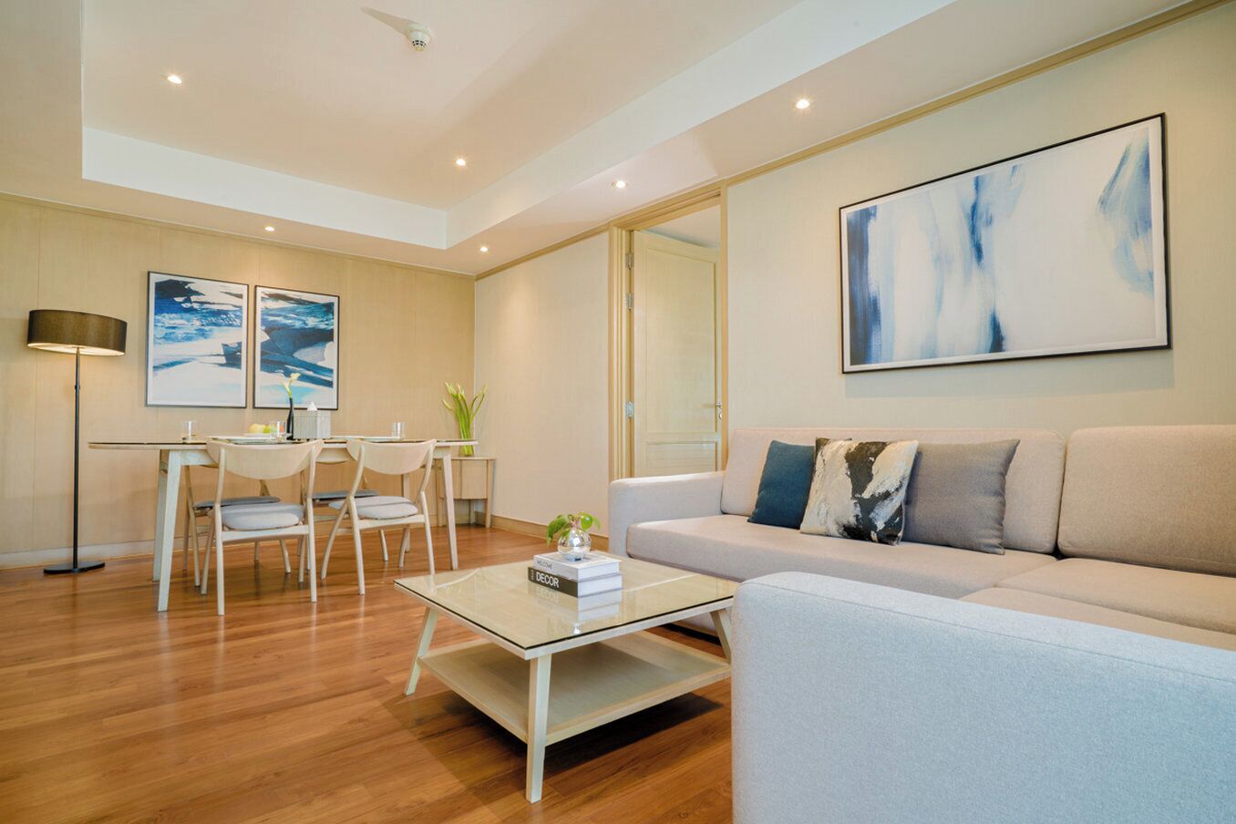 A modern living room with a sofa, coffee table, and dining area.