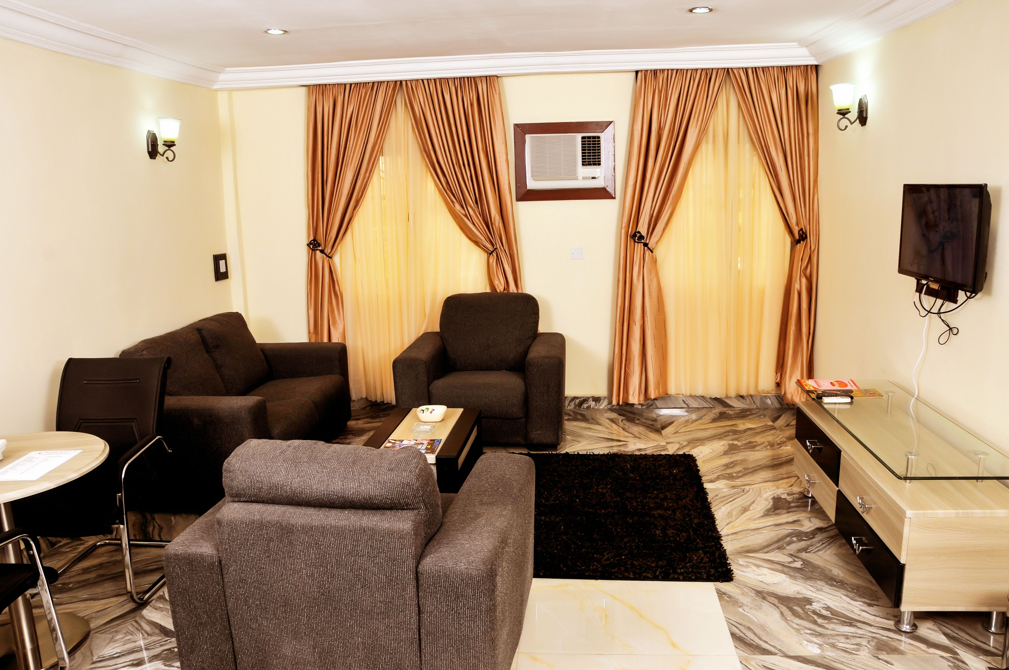 A living room with two sofas, a coffee table, a TV, and a glass cabinet.