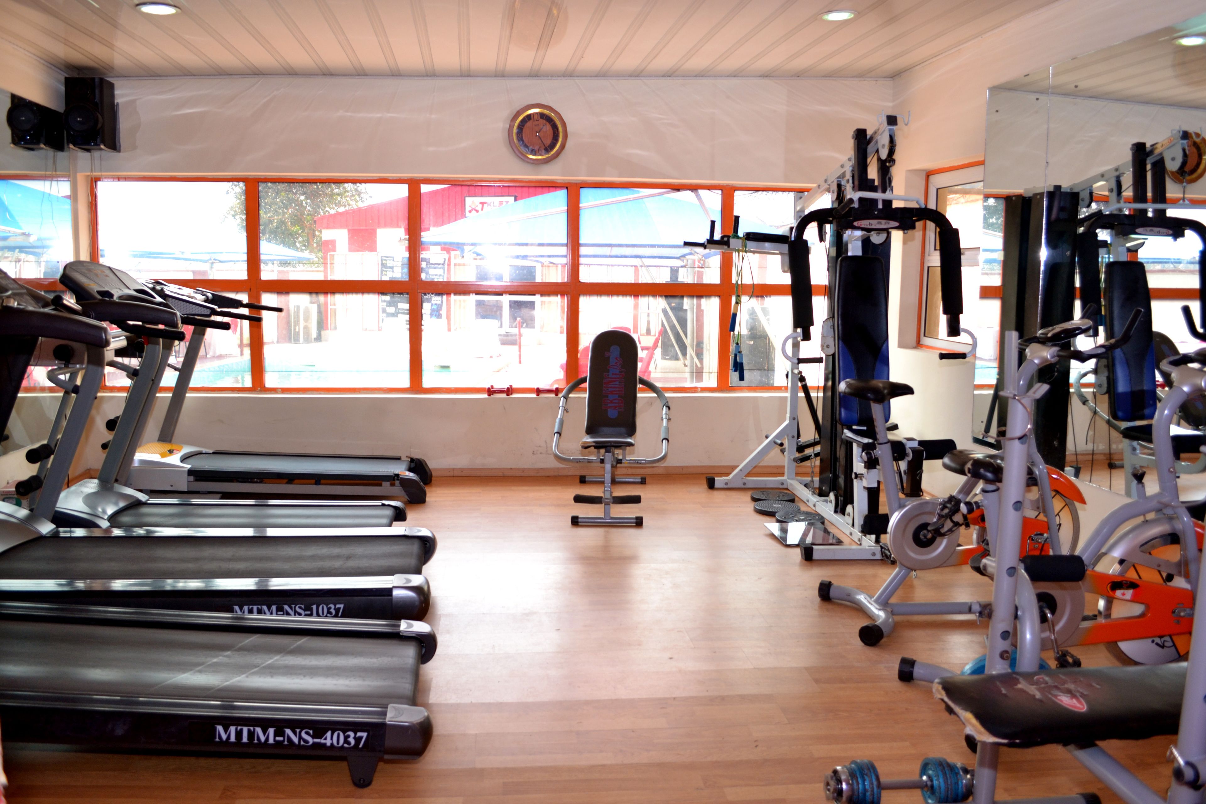 Un gimnasio con cintas de correr, máquinas de pesas y una banca.