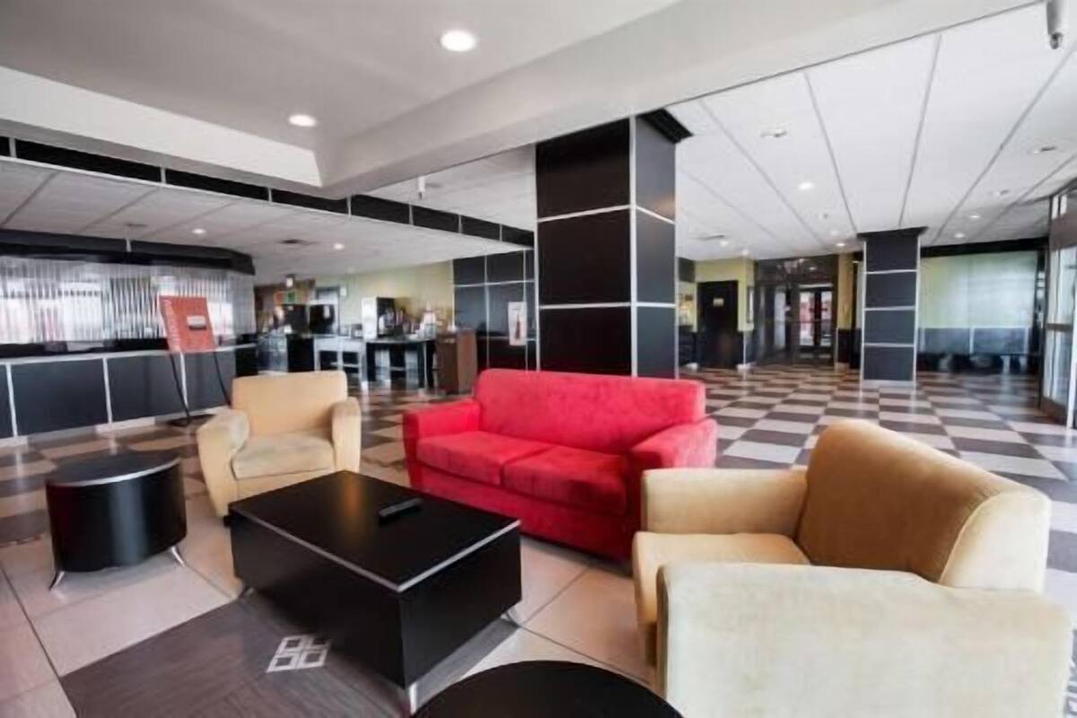 A lobby with a checkered floor, a red sofa, and a black coffee table.