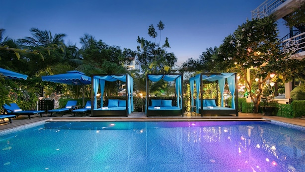 A swimming pool with blue lounge chairs and a covered seating area. - Hoi An Golden Holiday Elite (Da Nang)